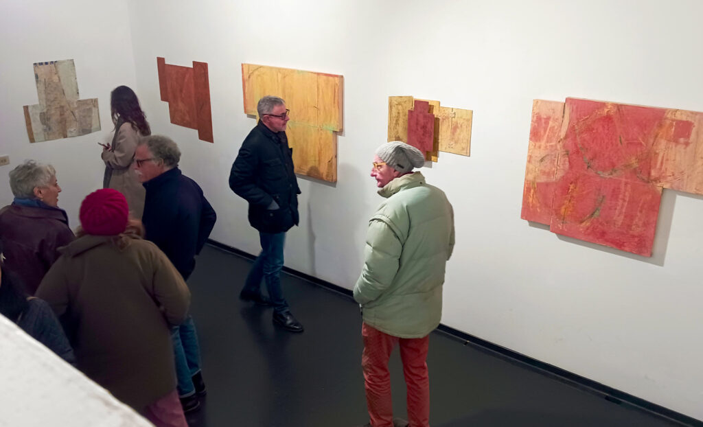 People mingling with artist Donald Fels at his exhibit